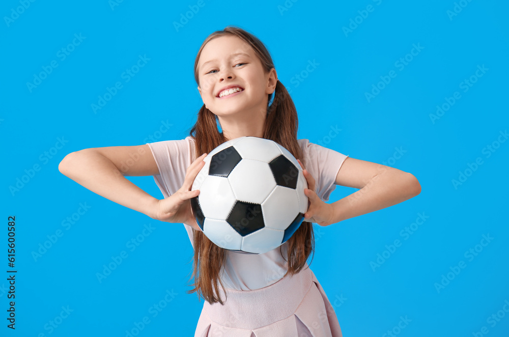 Little girl with soccer ball on blue background