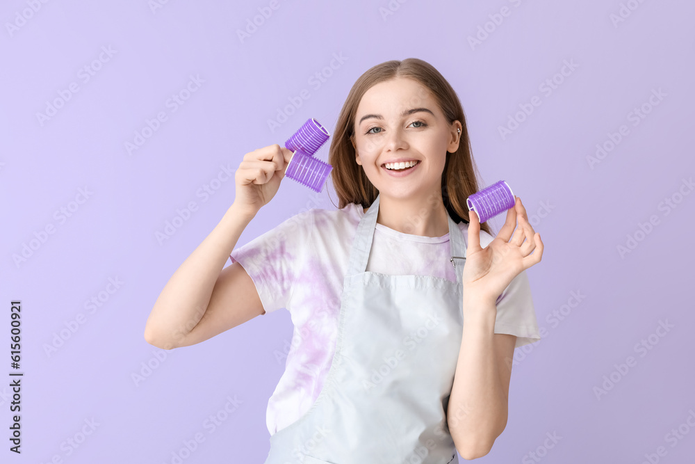 Female hairdresser with curlers on lilac background