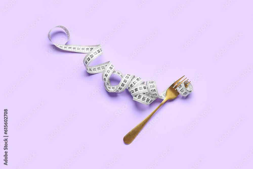 Fork with measuring tape on lilac background