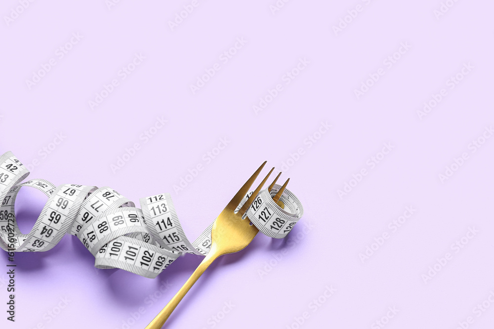 Fork with measuring tape on lilac background