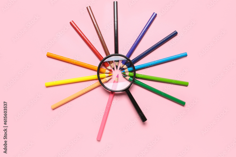 Magnifier with frame made of colorful pencils on pink background