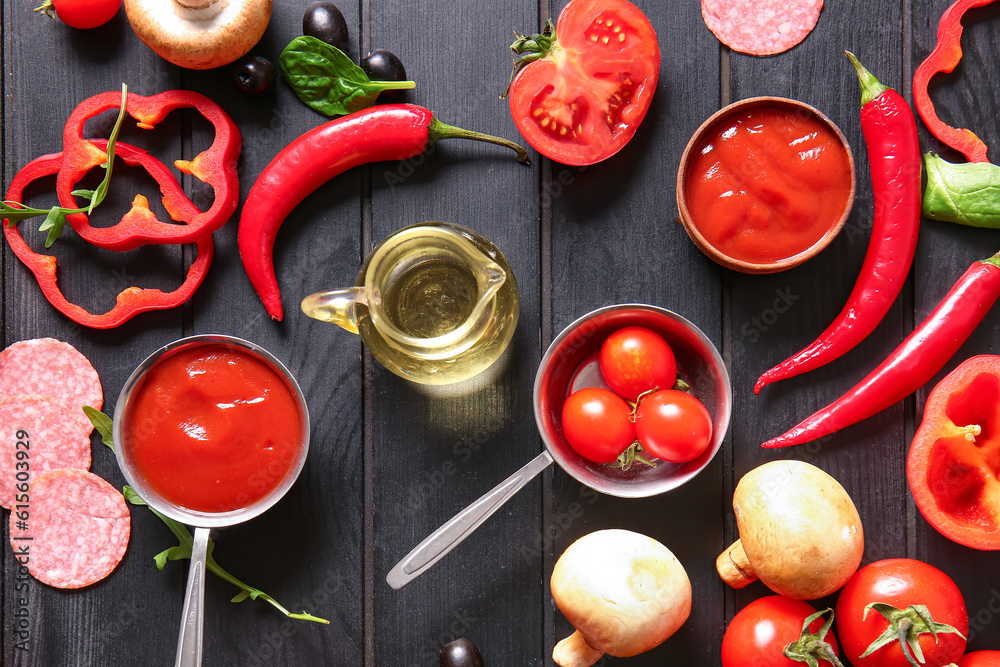 Different ingredients for preparing pizza on dark wooden background