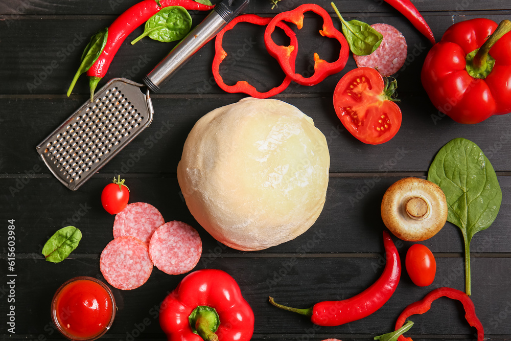 Different ingredients for preparing pizza on dark background