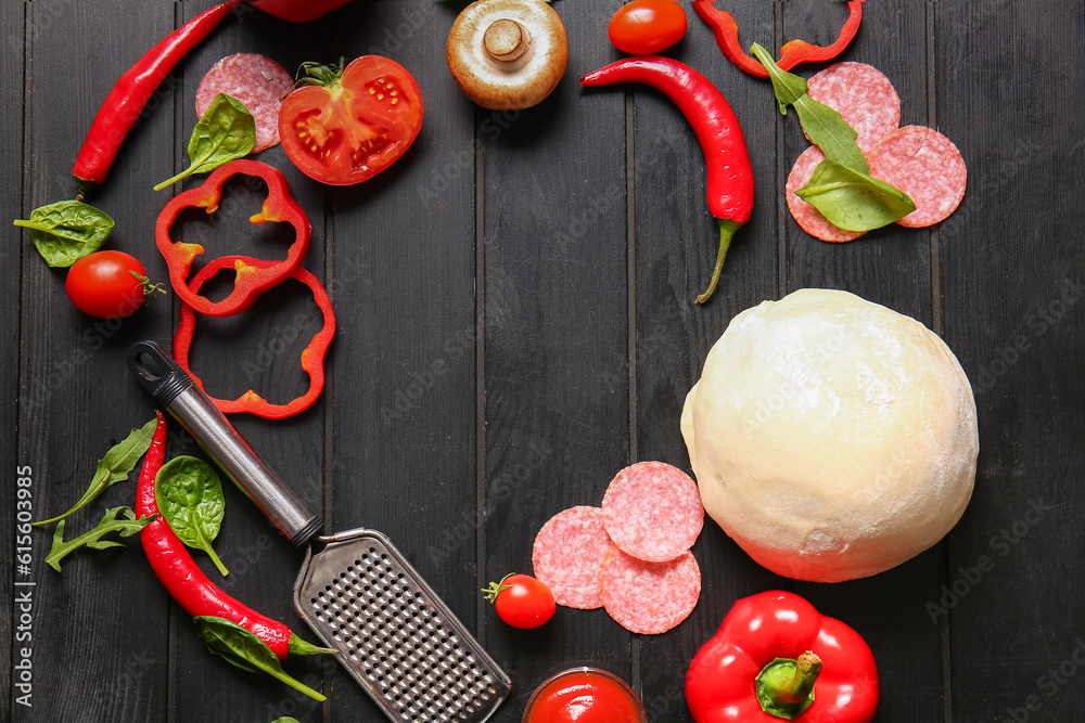 Frame made of fresh ingredients for preparing pizza on dark wooden background