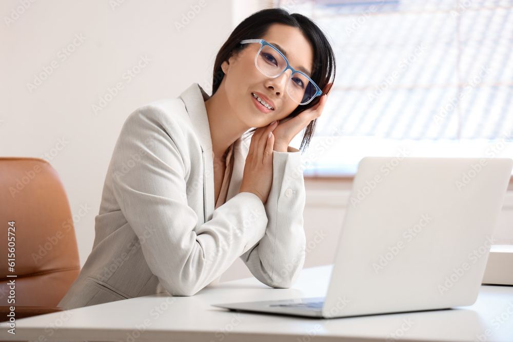 Beautiful Asian businesswoman in stylish eyeglasses in office