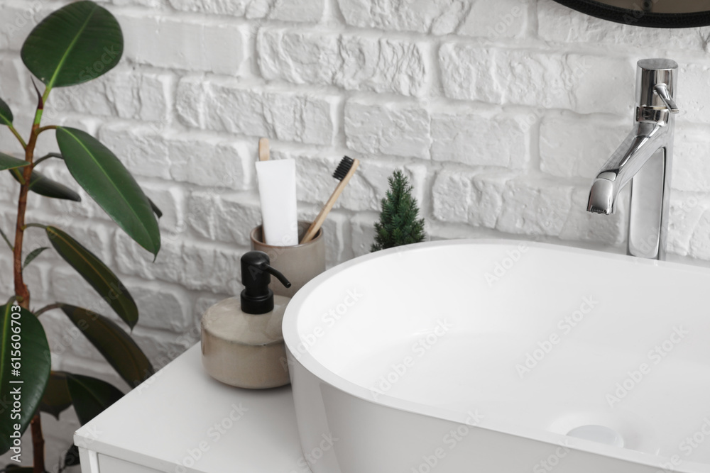 Sink bowl and bath accessories on table in bathroom, closeup