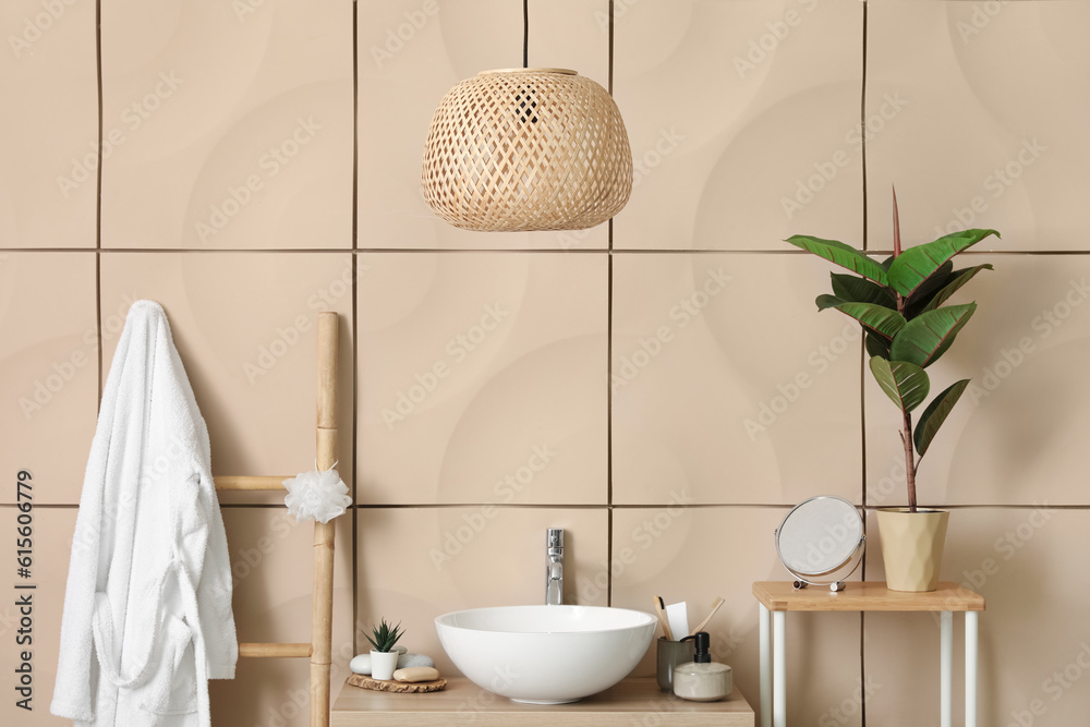 Sink bowl with bath accessories on table in bathroom