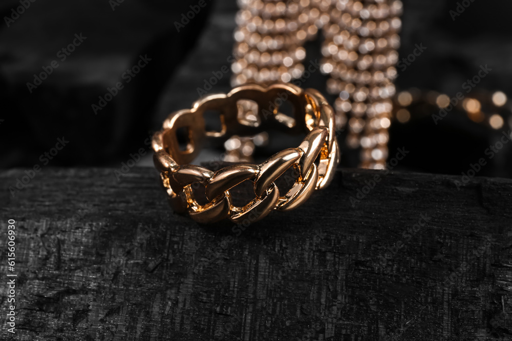 Beautiful ring and earrings on black charcoal, closeup