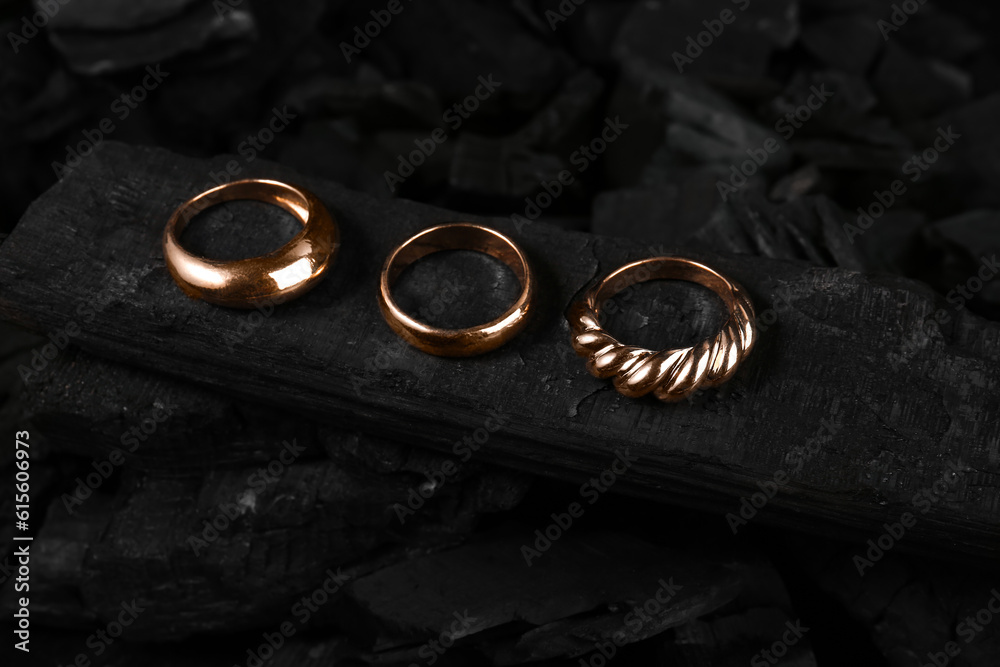 Beautiful rings on black charcoal, closeup