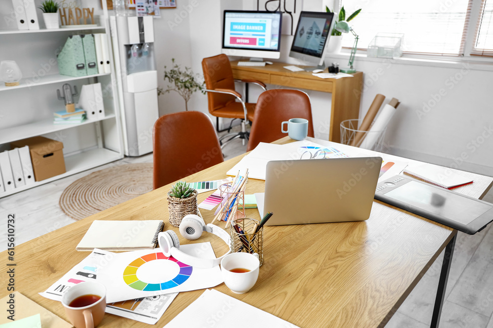 Graphic designers workplace with laptop in office