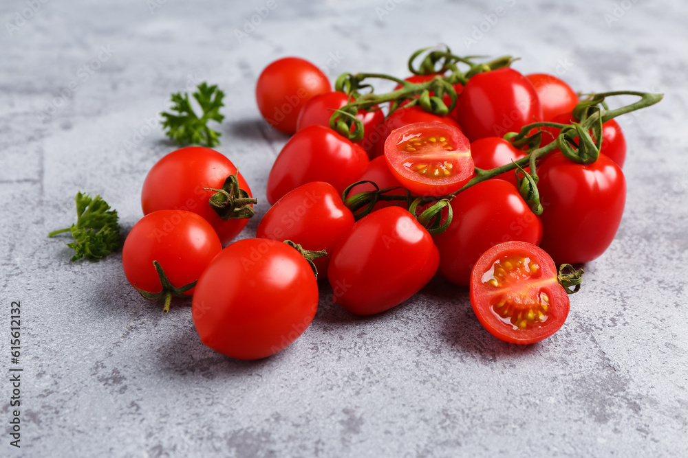 Fresh cherry tomatoes and parsley on grey background