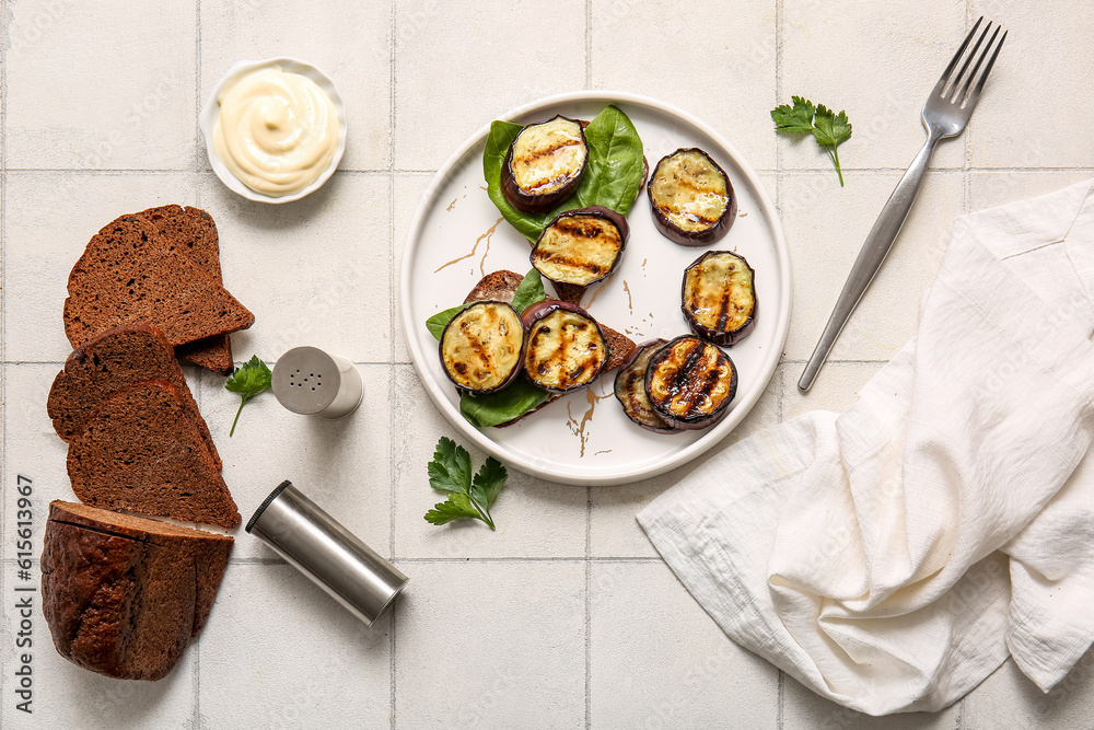 Toasts with delicious grilled eggplants, bread and sauce on light background