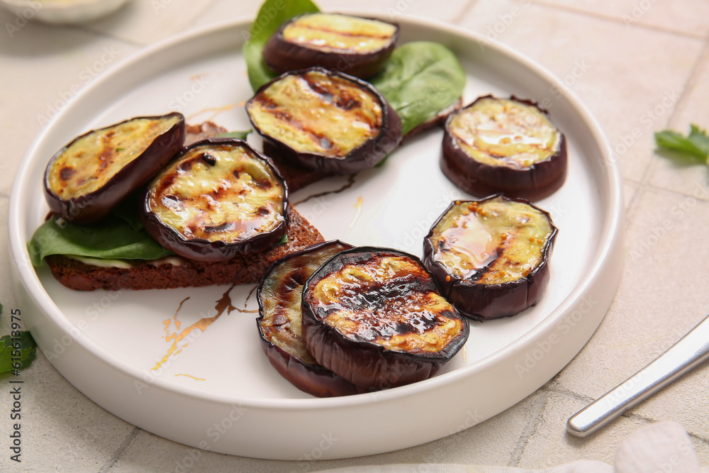 Toasts with delicious grilled eggplants on light background