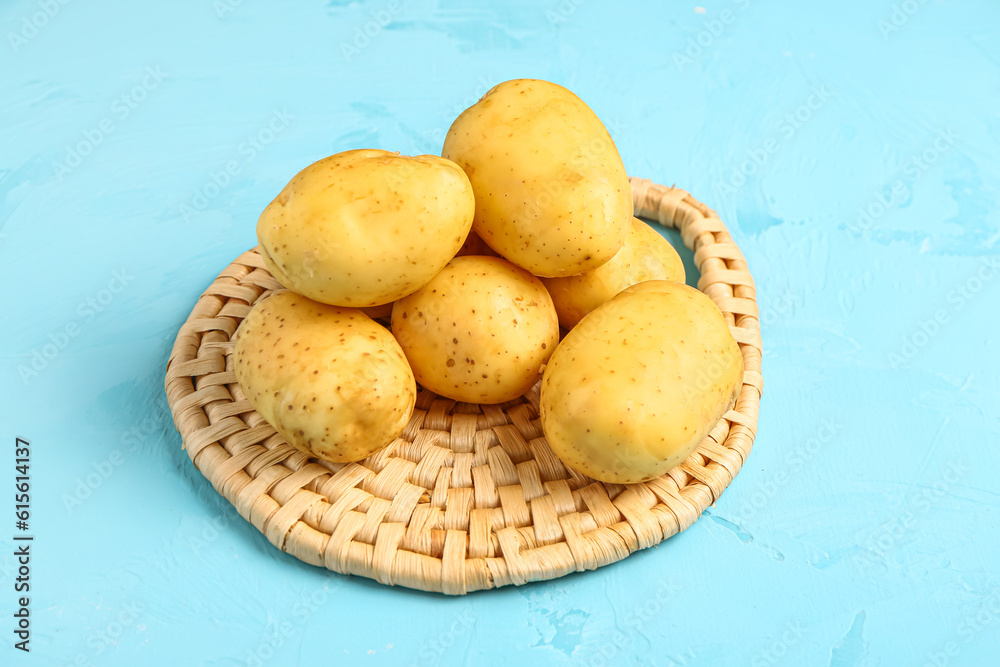 Raw baby potatoes on blue background