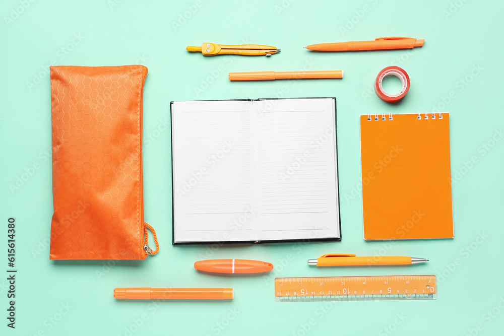 Notebooks with pencil case and different stationery on turquoise background