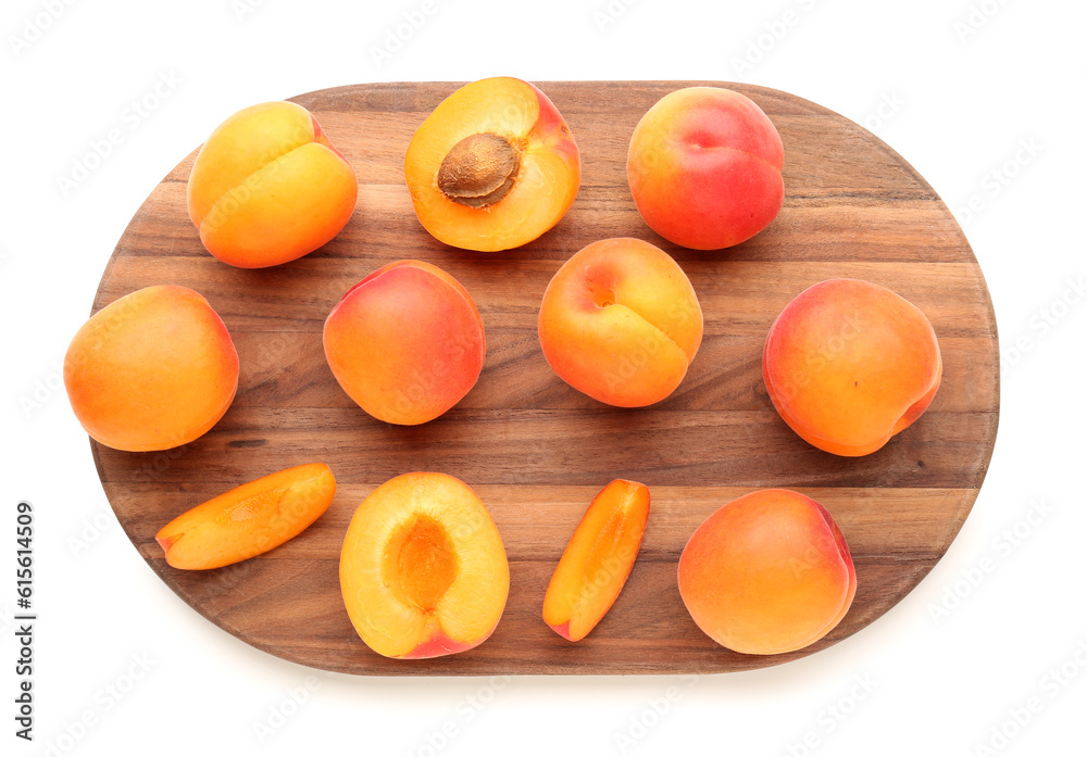 Wooden board with ripe apricots isolated on white background