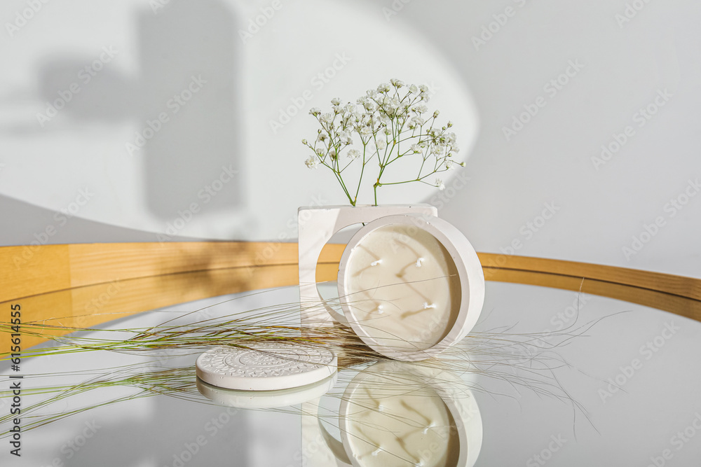 Gypsophila flowers and candle on mirror in room, closeup