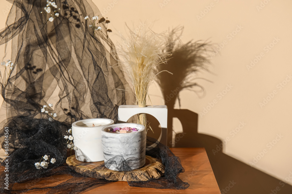 Gypsophila flowers and candles on table in room