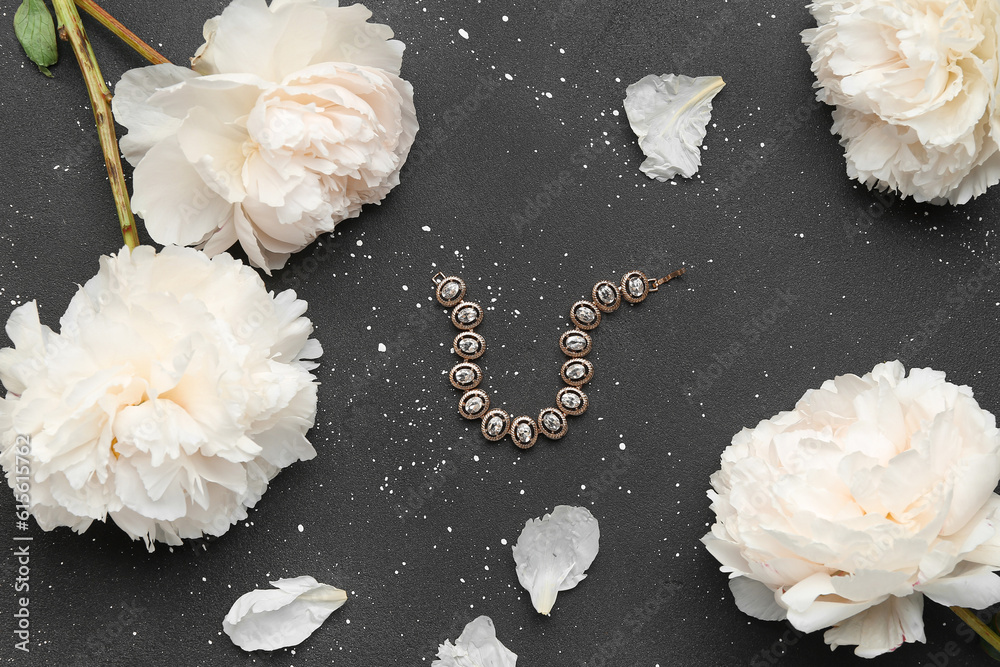 Composition with stylish female bracelet and beautiful peony flowers on dark background