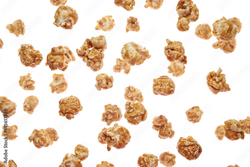 Flying tasty caramel popcorn on white background