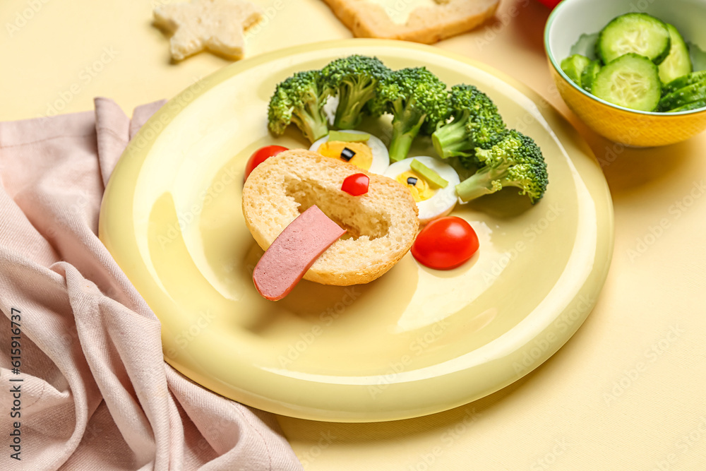 Plate with funny breakfast in shape of face and vegetables on beige background