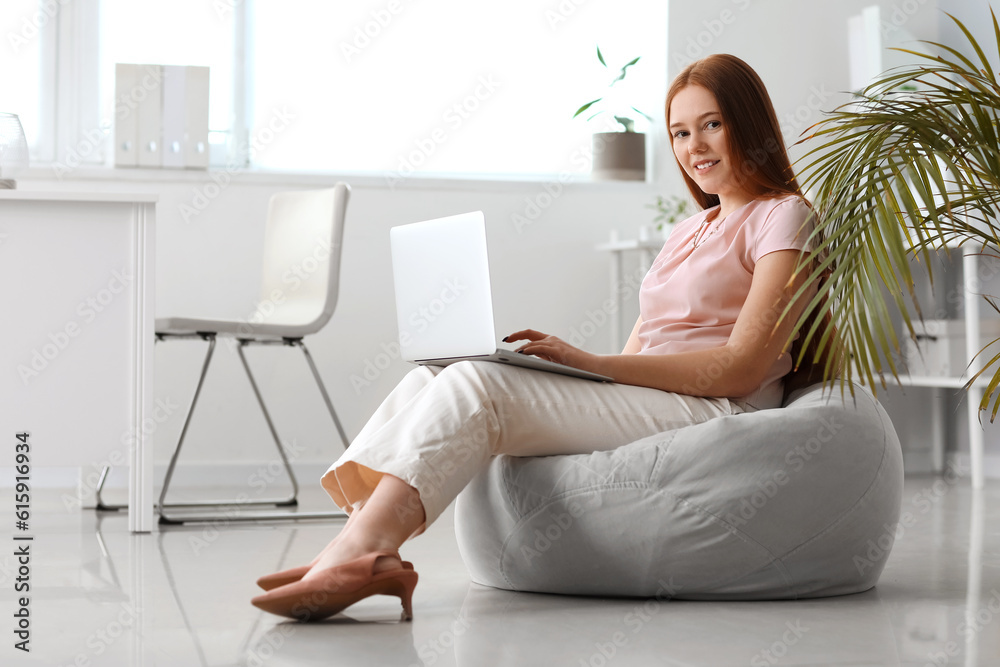 Female programmer working with laptop in office