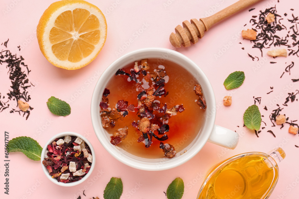 Composition with glass of fruit tea, lemon, mint and honey on pink background