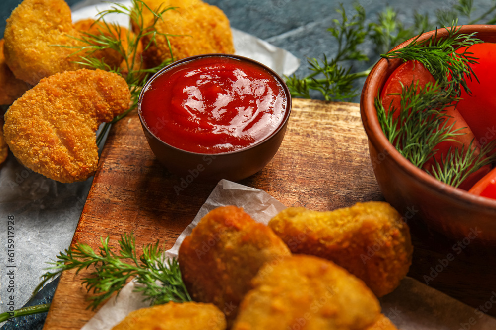 Wooden board of tasty nuggets with ketchup on table, closeup