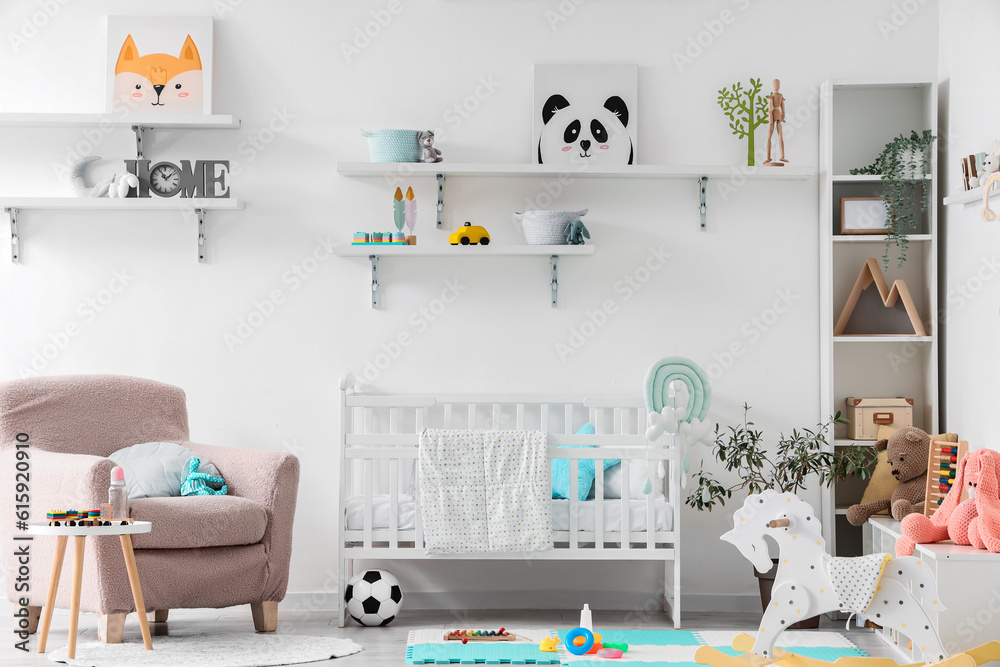 Stylish interior of childrens room with baby bed and toys