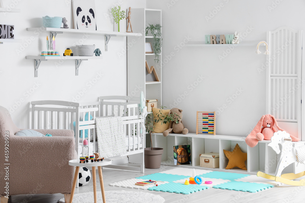 Stylish interior of childrens room with baby bed and toys