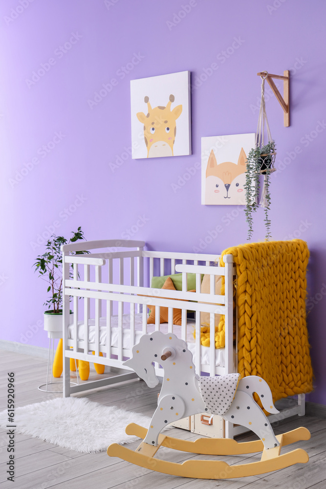 Stylish interior of childrens room with baby bed and rocking horse