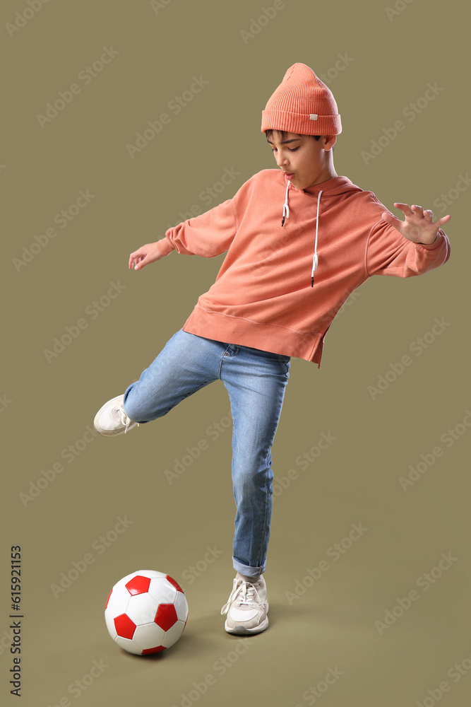 Little boy playing with soccer ball on color background