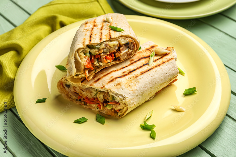 Plate of tasty shawarma on green wooden background