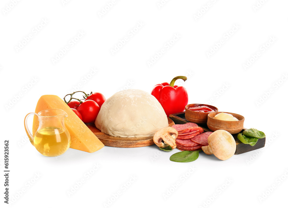 Raw dough and ingredients for preparing pizza on white background