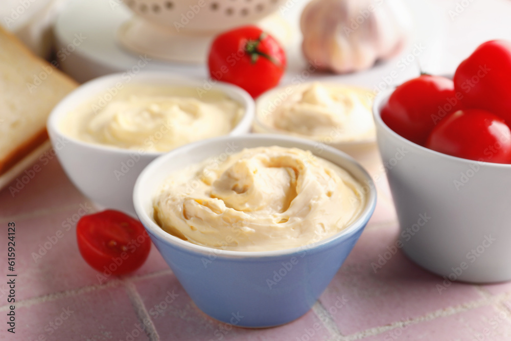 Bowl of tasty cream cheese on pink tile background