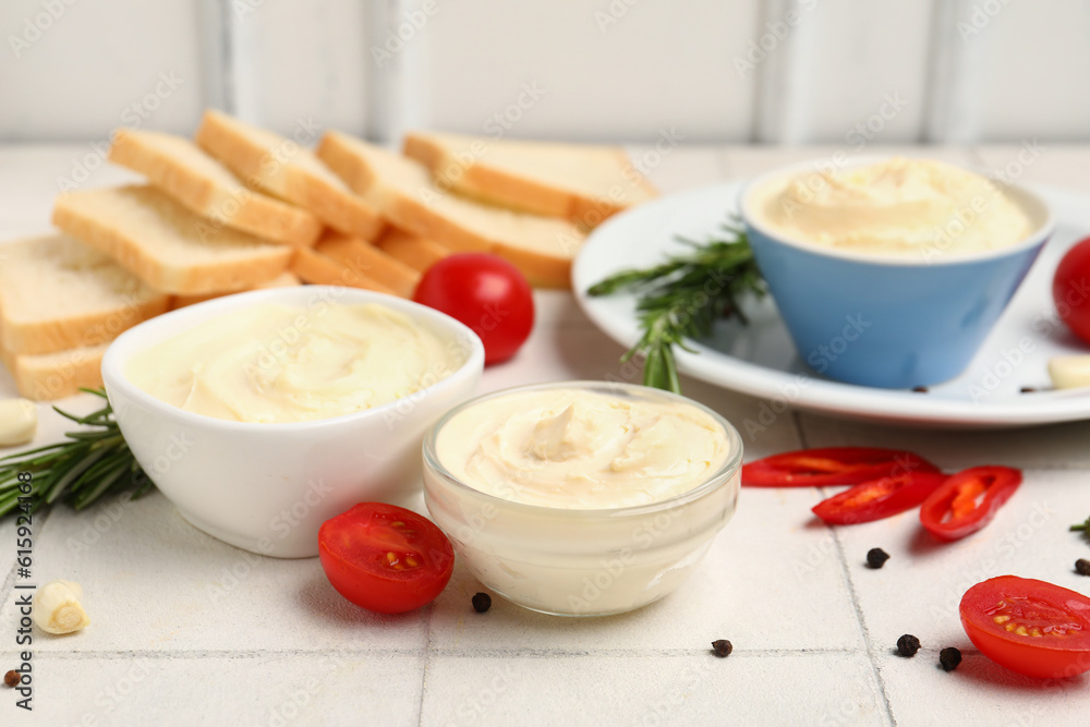 Bowls of tasty cream cheese on table