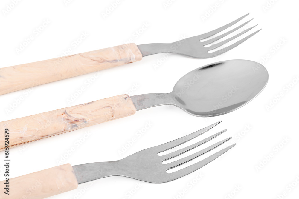 Stainless steel forks and spoon with plastic handles on white background