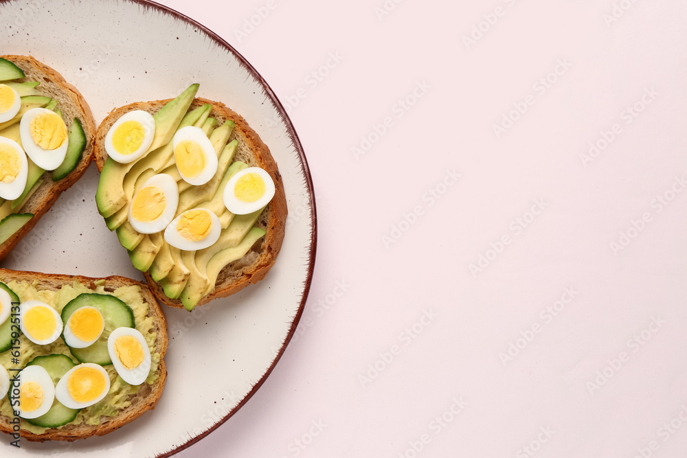 Tasty toasts with quail eggs, avocado and cucumber on light background