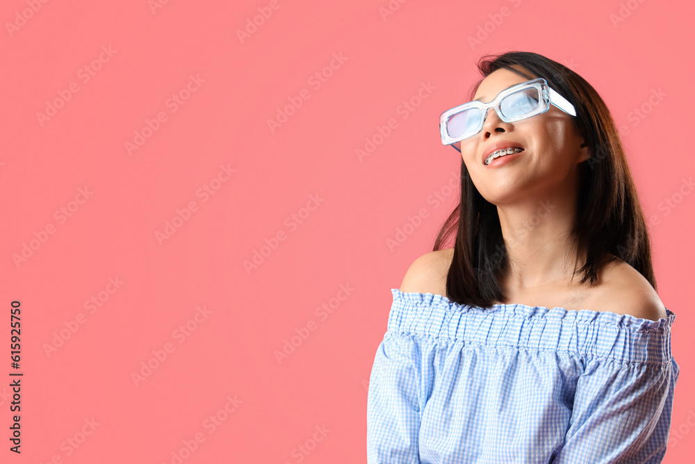 Beautiful Asian woman in stylish sunglasses on pink background