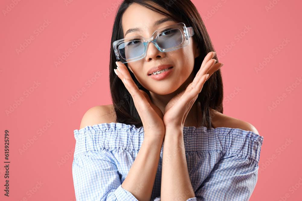 Beautiful Asian woman in stylish sunglasses on pink background, closeup