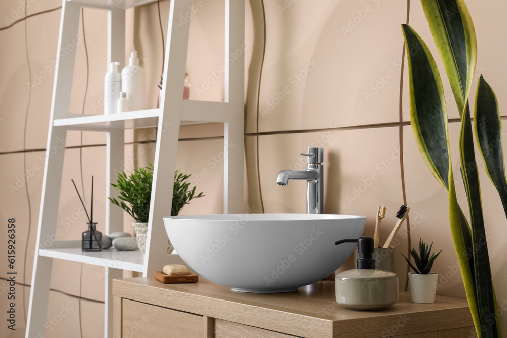 Sink bowl and bath accessories on table in bathroom