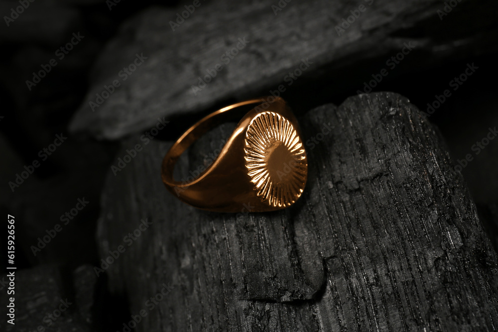 Beautiful ring on black charcoal, closeup