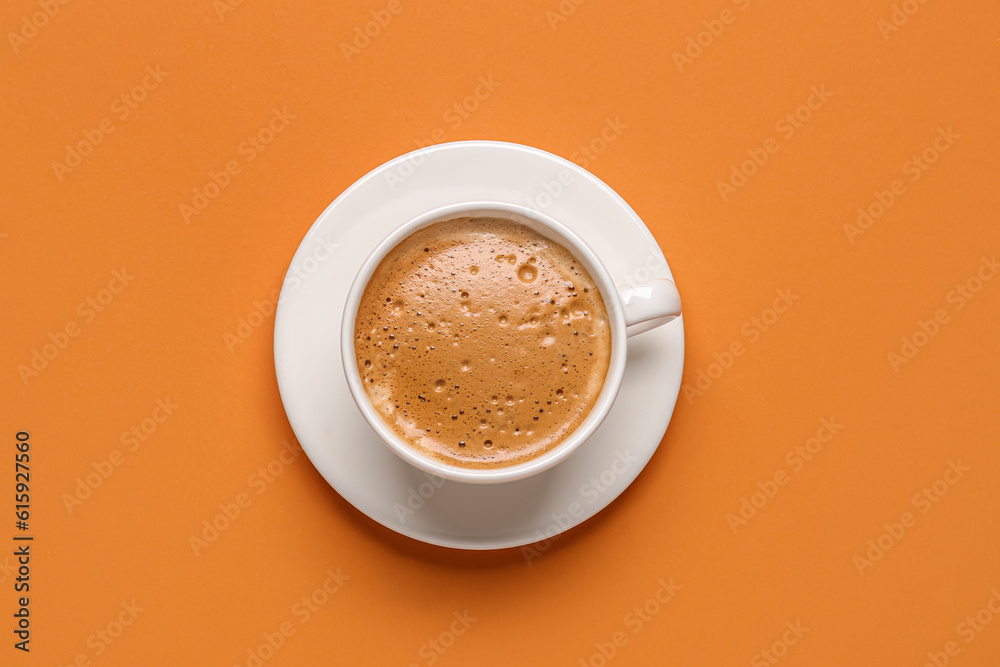 Cup of hot espresso on orange background