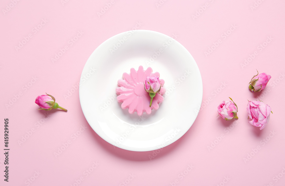 Plate of panna cotta with beautiful rose flowers on pink background