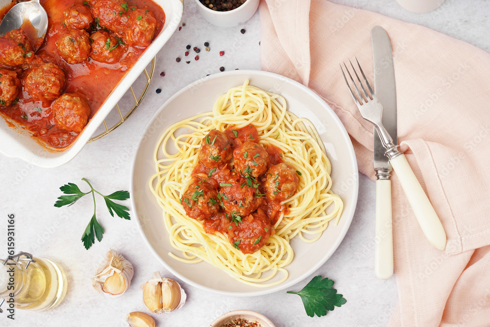 Plate of boiled pasta with tomato sauce and meat balls on white table