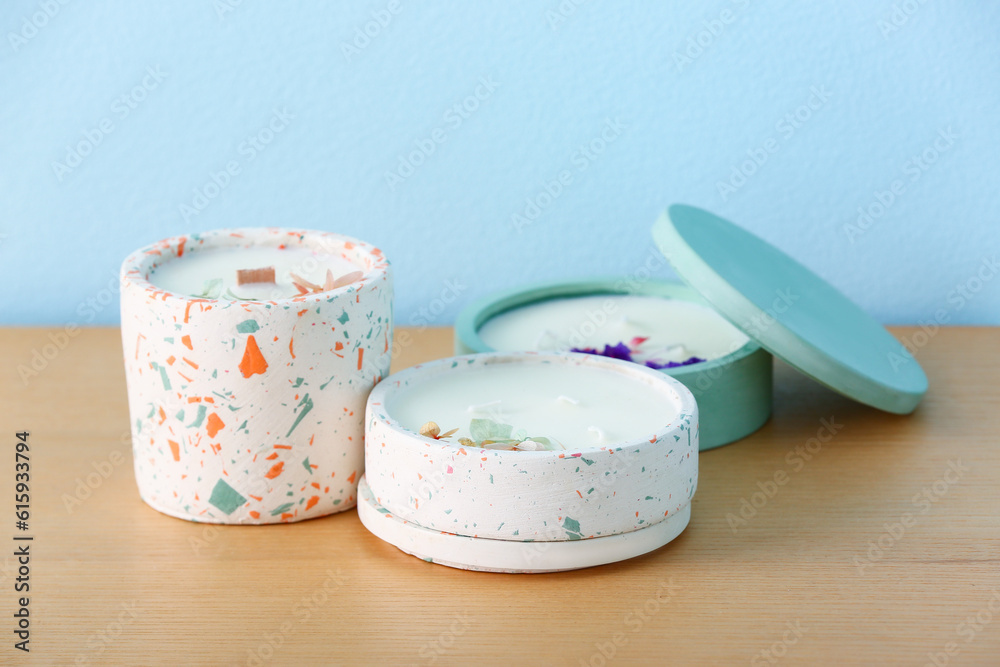 Holders with candles on table near blue wall in room, closeup