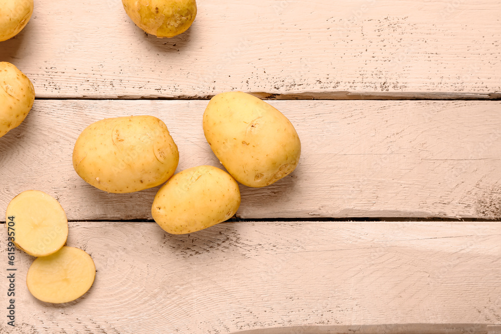 Raw baby potatoes on white wooden background