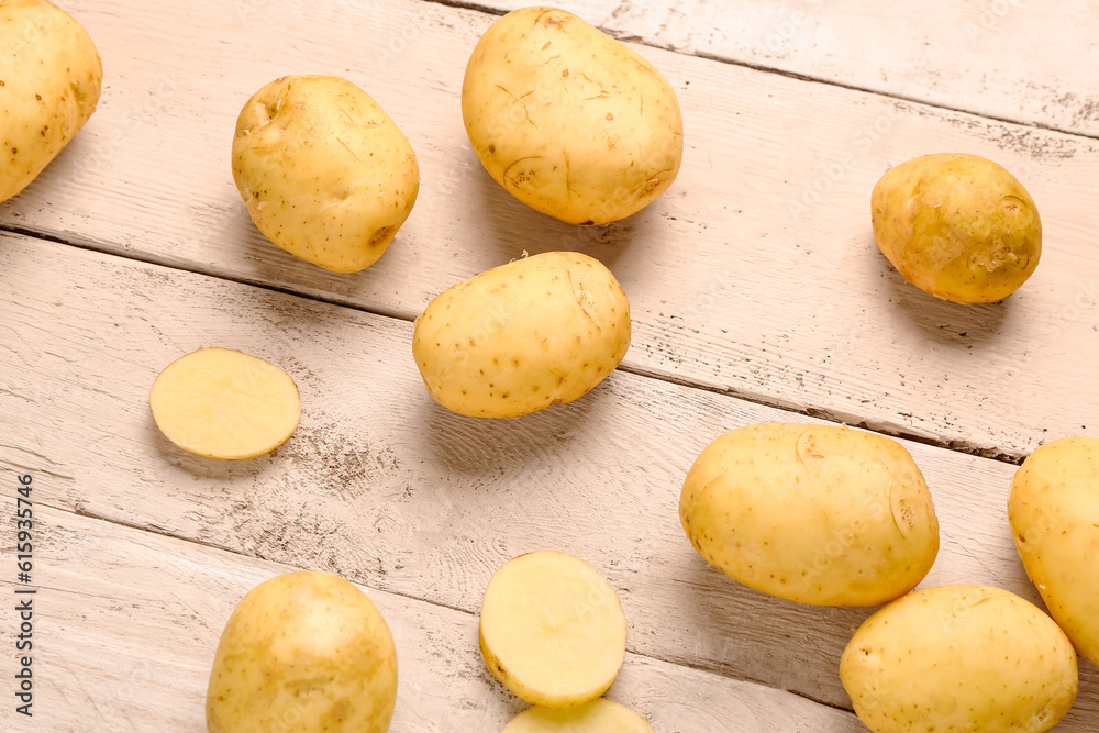 Raw baby potatoes on white wooden background