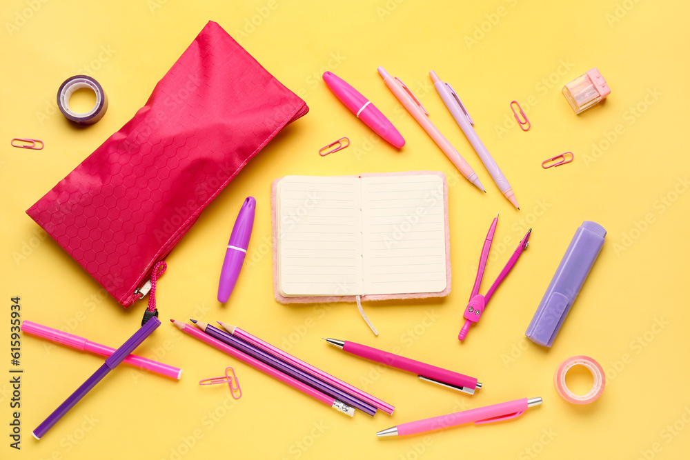 Notebook with pencil case and different stationery on yellow background