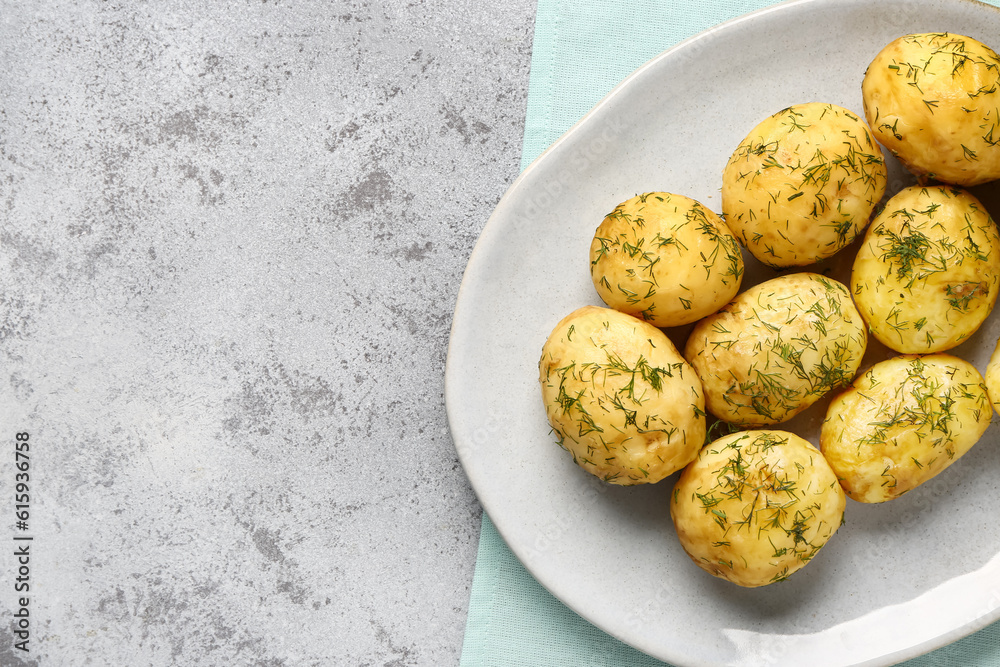 Plate of boiled baby potatoes with dill on grey background